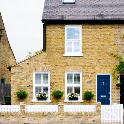 house exterior with bricked wall and blue door