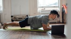 Man holding a plank at home