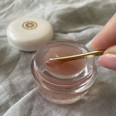 a hand scooping product out of one of the best lip masks from the article 