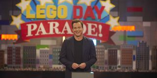 will arnett standing in front of LEGO skyscrapers on LEGO masters season 2 premiere