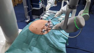 A surgical robot performing surgery on a fake human torso at MWC 2023.