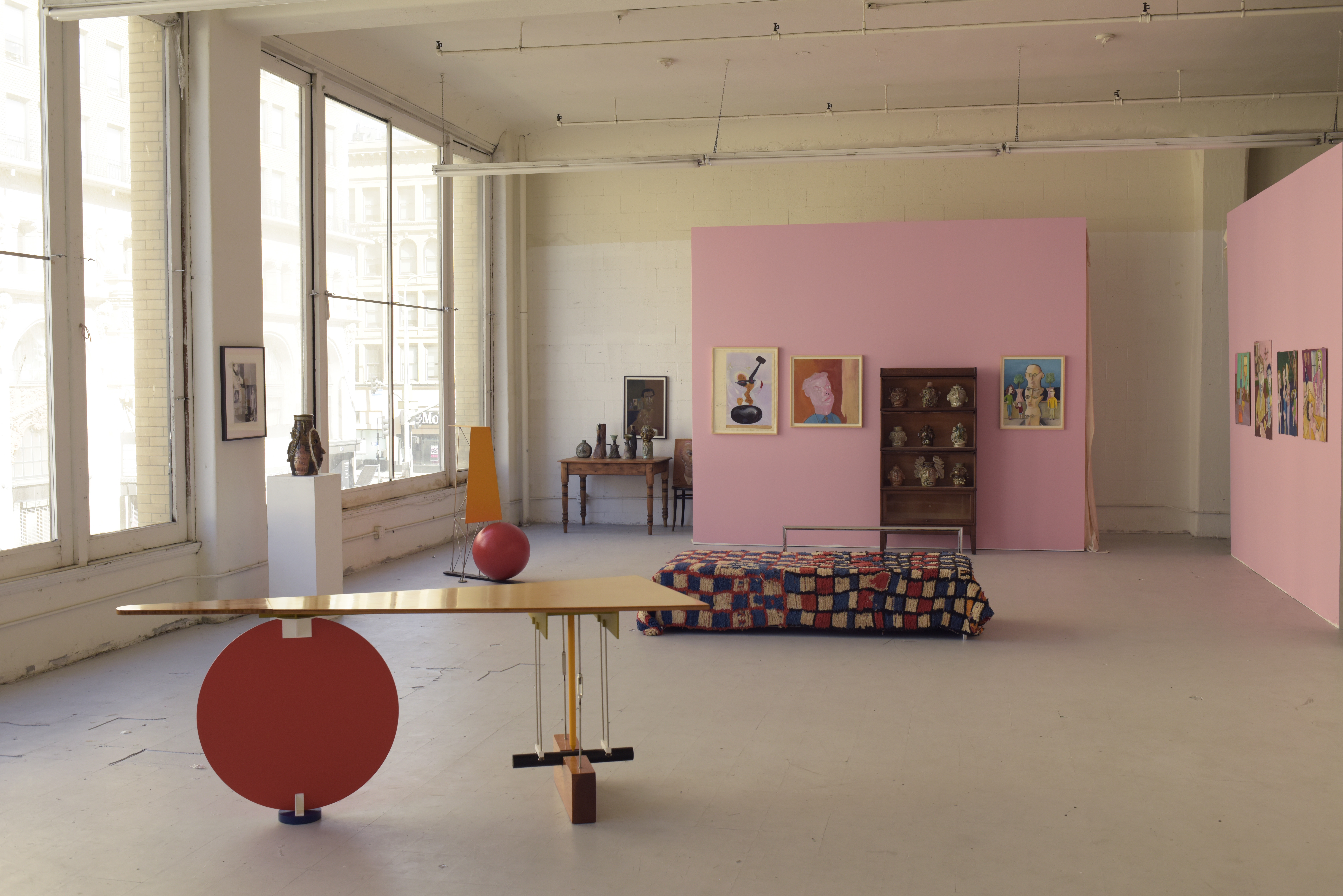 A gallery space with pink walls and contemporary furniture