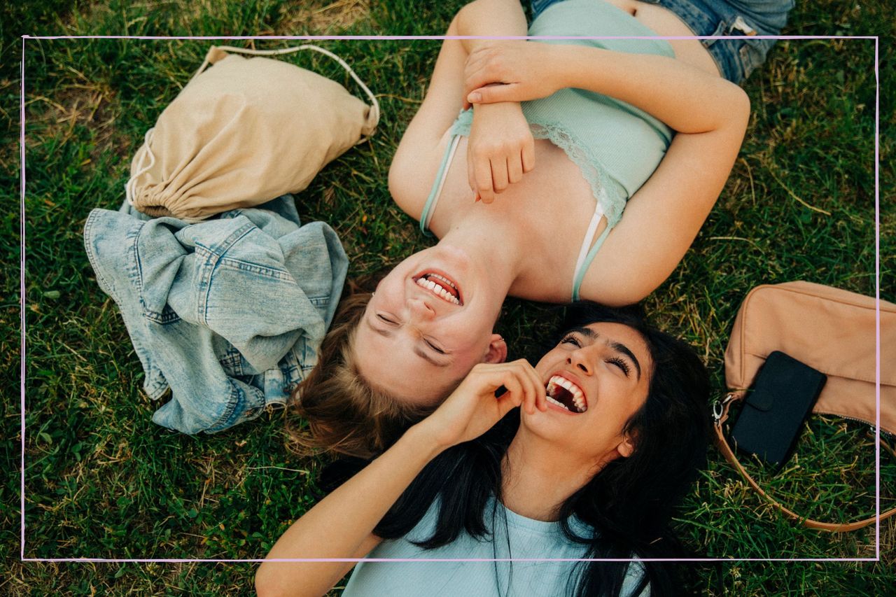 Two teenage girls laying down and smiling