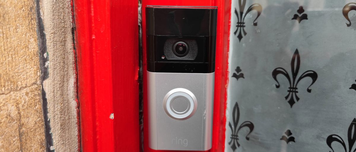 The Ring Video Doorbell 4 installed on a red door frame