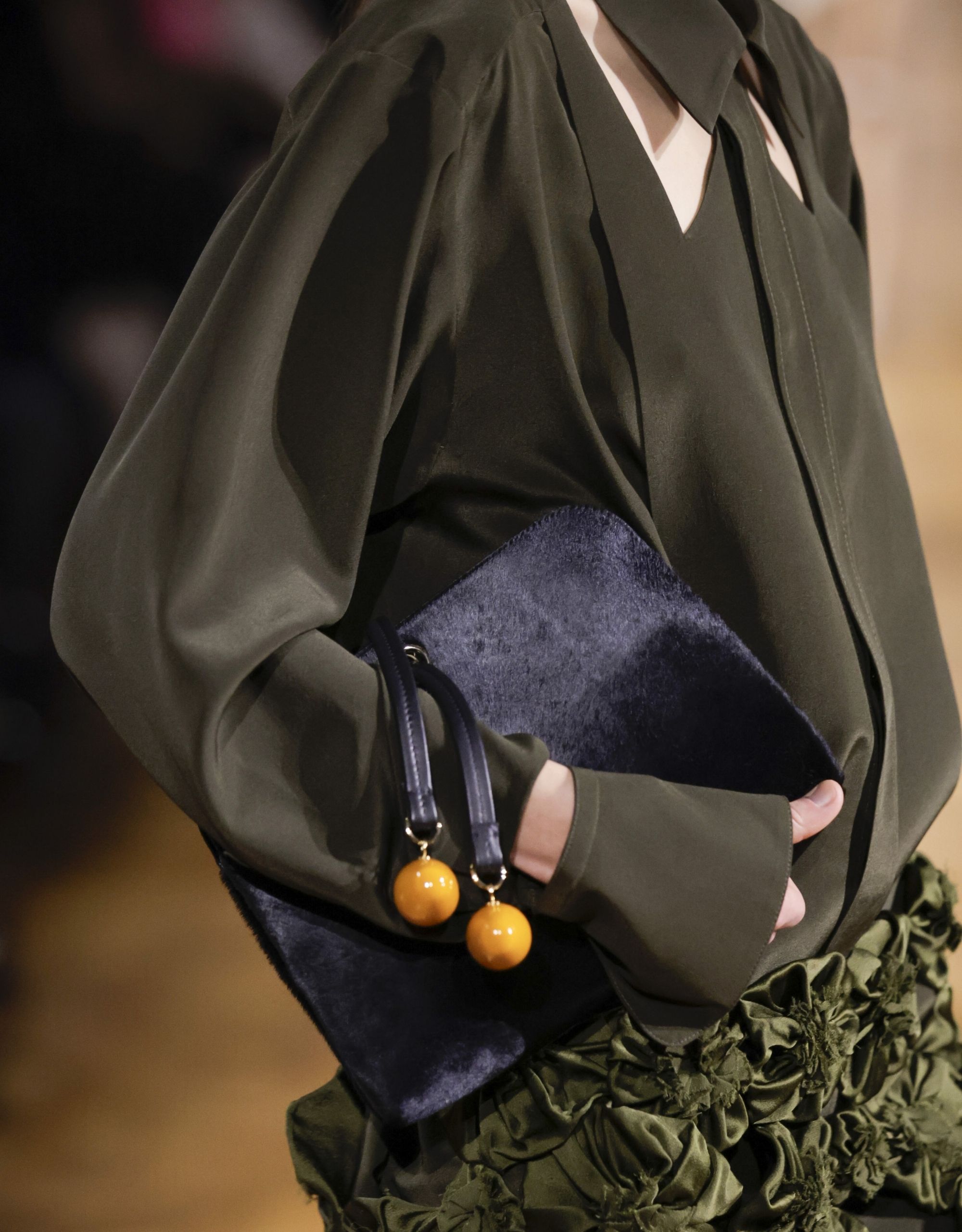 Model on the Victoria Beckham runway holding a clutch bag