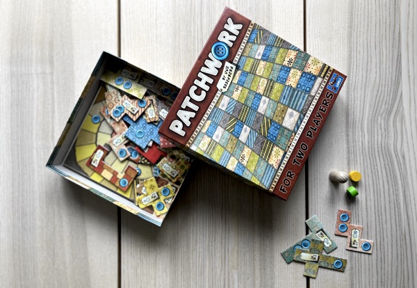En öppnad förpackning av spelet Patchwork på ett bord.