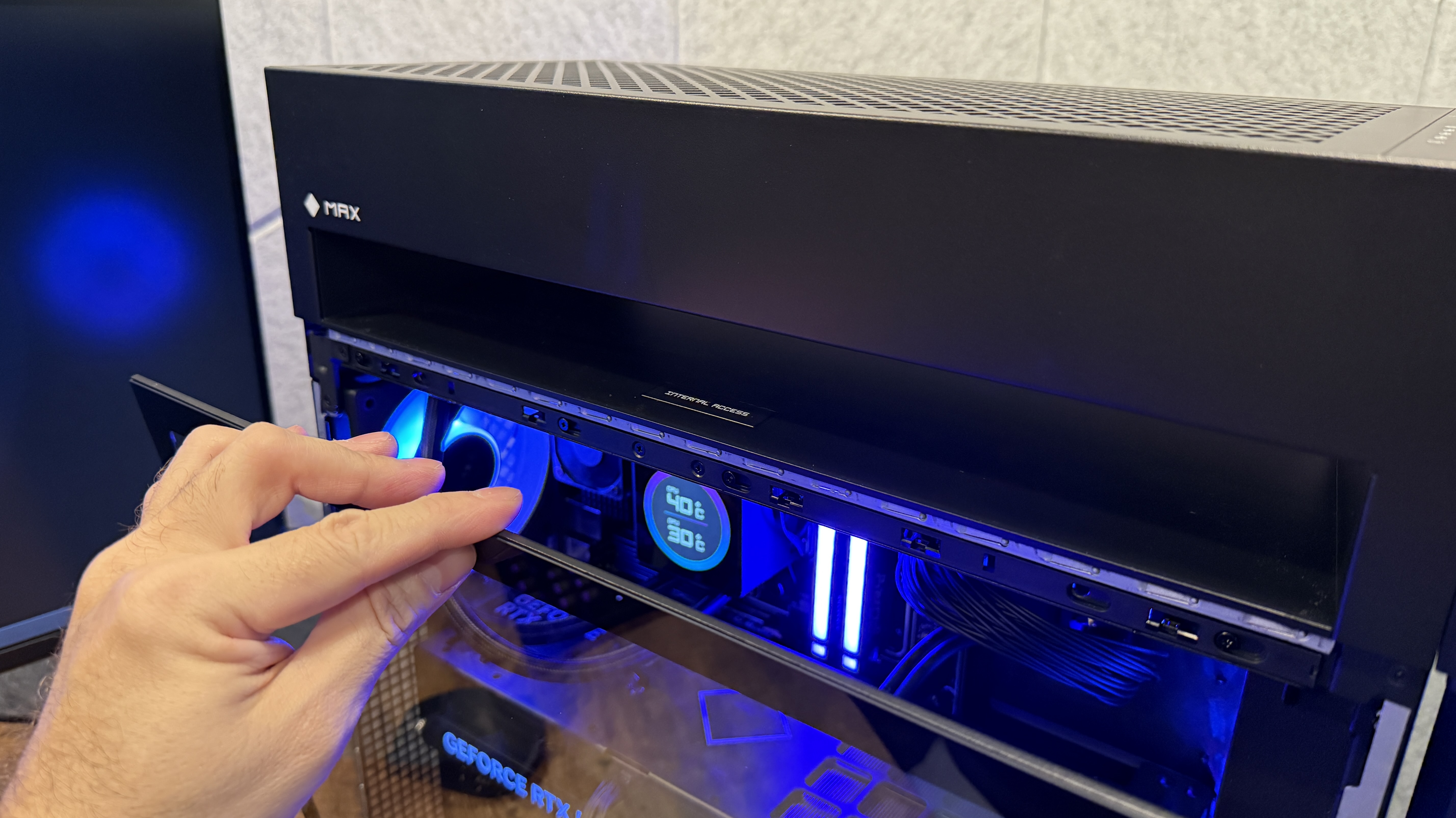 A person taking off the HP Omen Max 45L's glass side panel to access its components