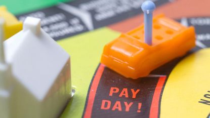 A board game with a toy car reaching the "Pay Day" spot.