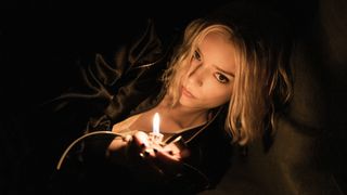 Anya Taylor-Joy as Lucky holding a lighter in a dark space.