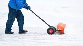 Man using a snow pusher in snow