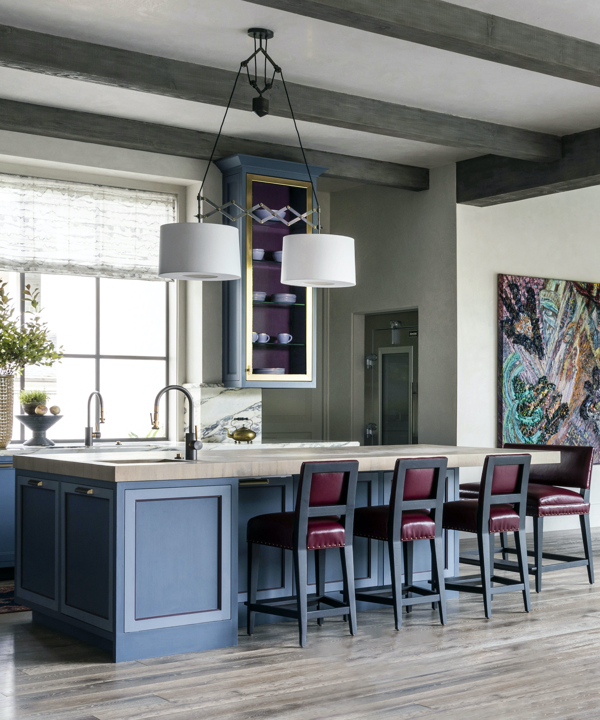 blue kitchen island with red leather stools