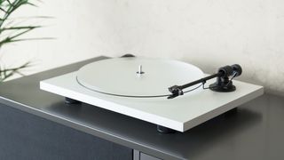 Pro-Ject Primary E in white finish on a grey shelf