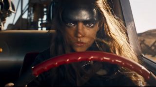 Anya Taylor-Joy as Furiosa driving a car looking determined in Furiosa.