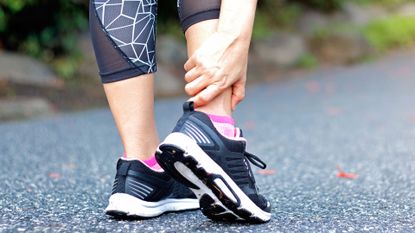 Best stability running shoes: pictured here, a runner holding their ankle