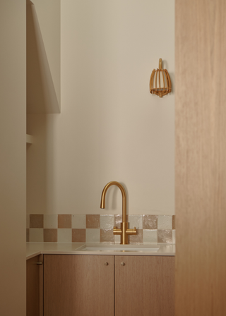 small kitchen nook with pale oak cabinetry and a checkerboard tile detailing