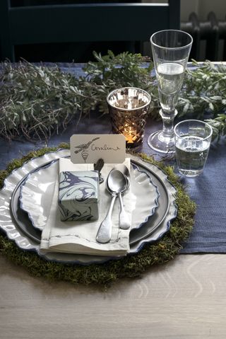 New Year table decor with gift wrapped in marbled paper