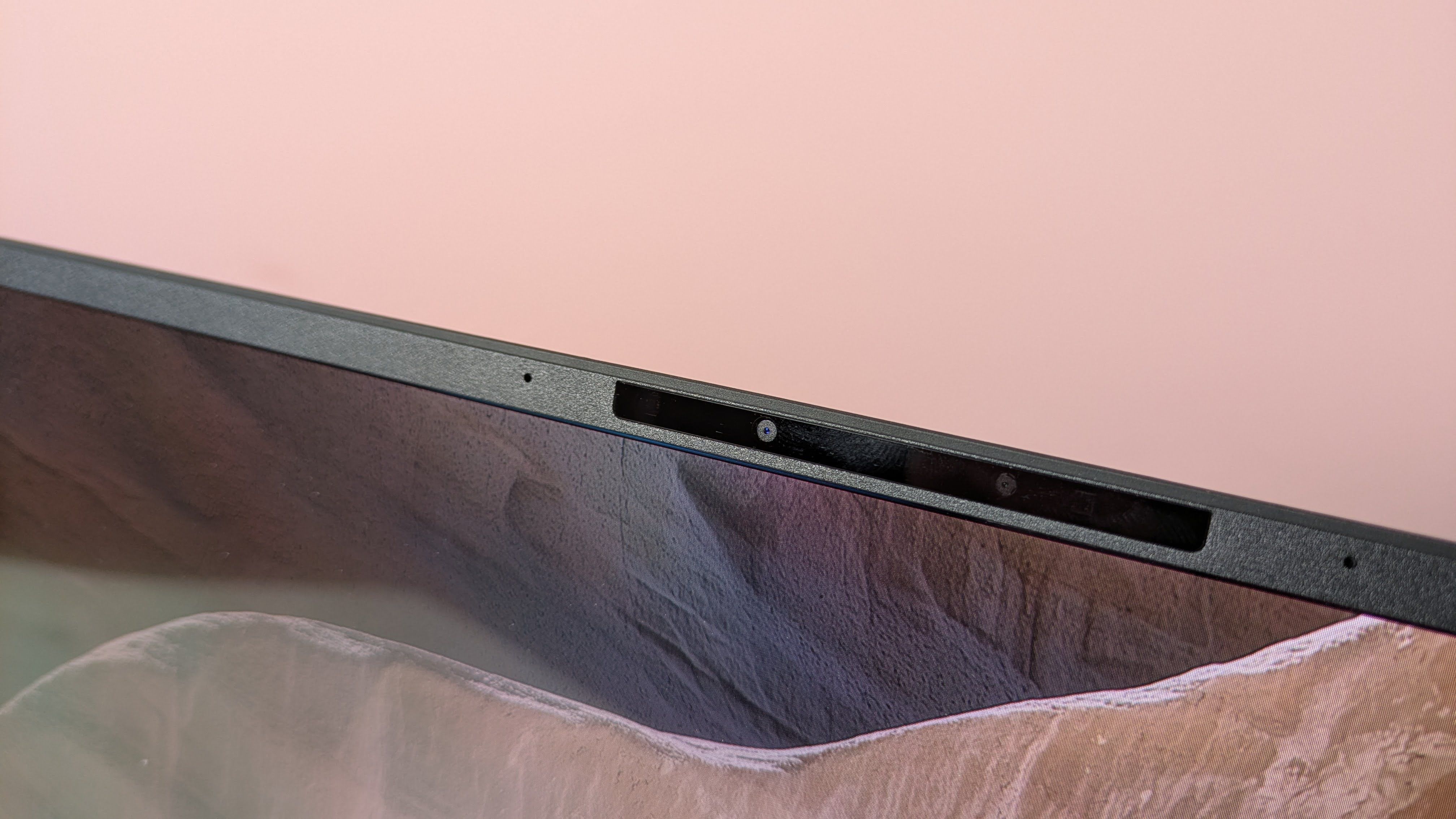 Close-up of webcam on Asus Zenbook A14, with pink wall in background