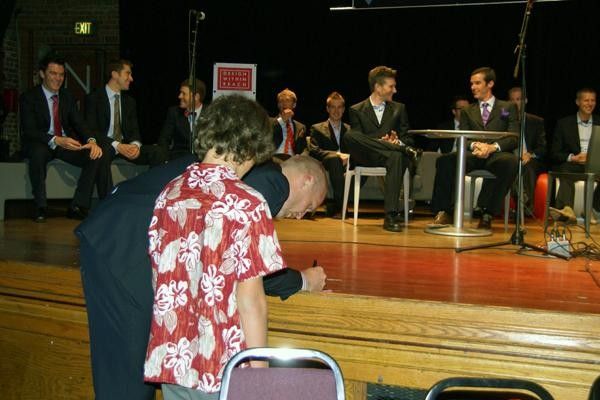 Maggie' graciously signs a 2004 Paris-Roubaix DVD for a anxious young fan.