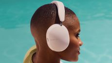 Sonos Ace headphones worn by a woman by a pool