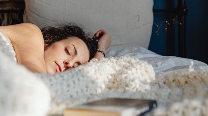 Woman asleep in bed, sleep & wellness tips
