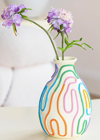 vase with colorful lines pattern holding a couple of blooms