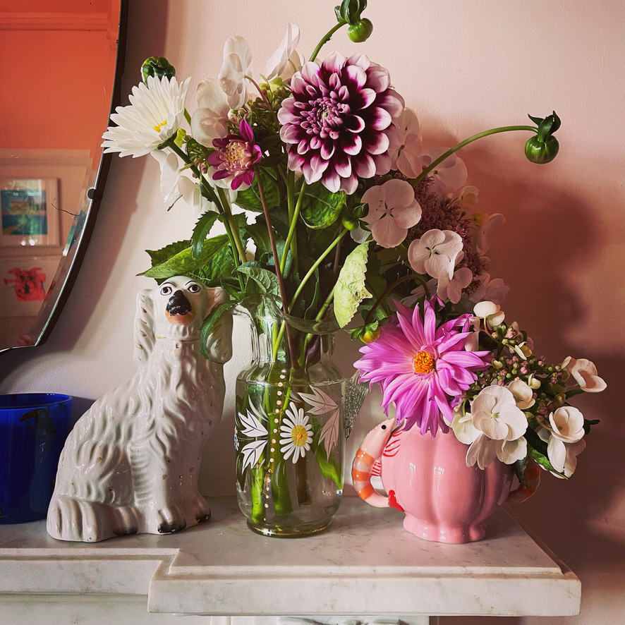 dahlias and other flowers on a mantle