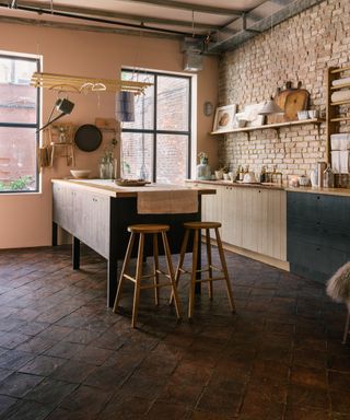 A black and pink kitchen with black and natural cabinetry and pale pink walls using Farrow & Ball's Setting plaster