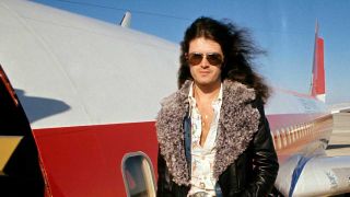 Glenn Hughes, posed, standing by plane 