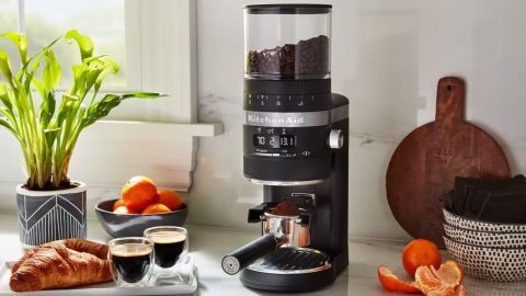 The KitchenAid Burr Coffee Grinder being used to grind espresso in a kitchen