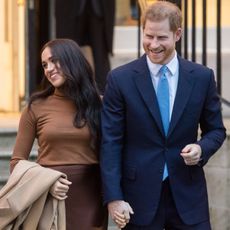 Prince Harry and Meghan Markle hold hands and walk out of an engagement