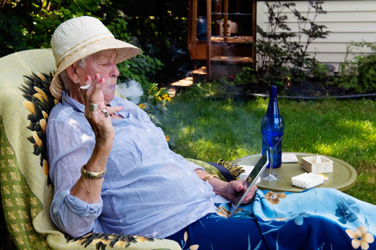 An older woman relaxing while smoking marijuana.