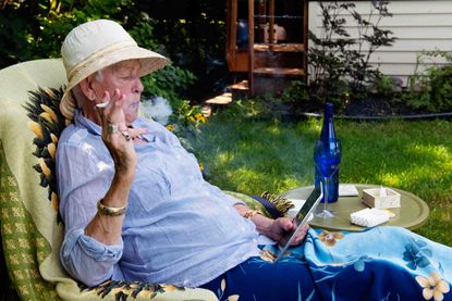 An older woman relaxing while smoking marijuana.