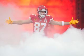 Travis Kelce emerges from the smoke in his Chiefs uniform getting ready for the Super Bowl.