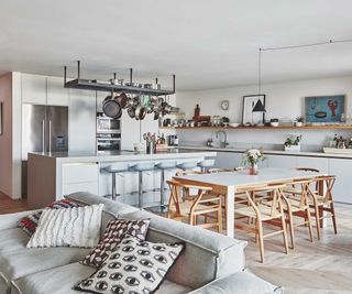 open-plan kitchen-diner and living space with grey sofa and wooden dining table and chairs