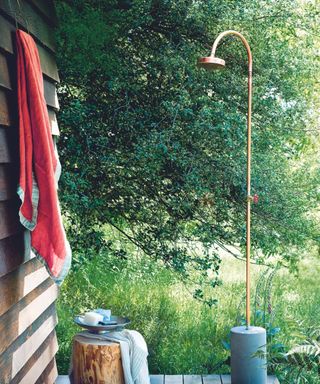 outdoor shower with wooden shed and towel