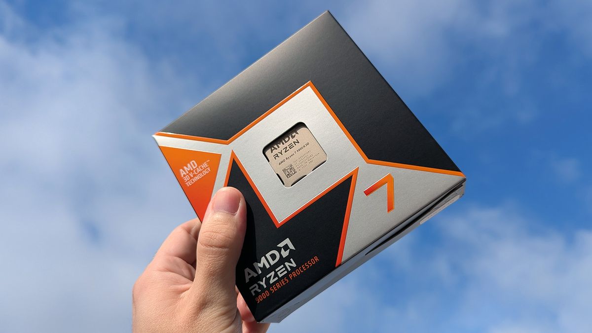 AMD Ryzen 7 9800X3D retail box held in front of a blue cloudy sky