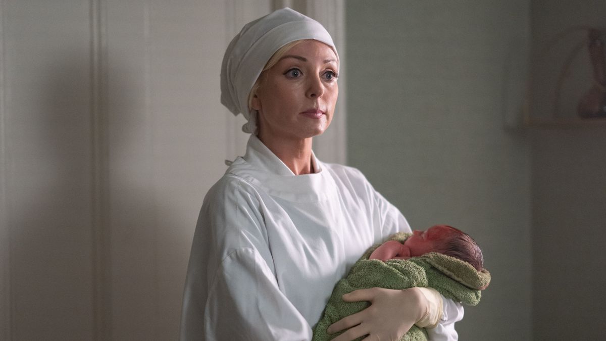 Trixie Franklin (HELEN GEORGE) holding a baby in Call the Midwife season 13 episode 1