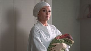 Trixie Franklin (HELEN GEORGE) holding a baby in Call the Midwife season 13 episode 1