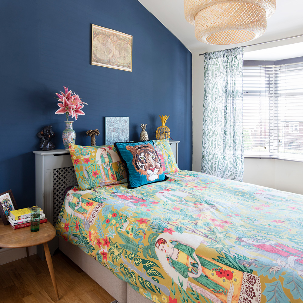 bedroom with blue wall and grey bed