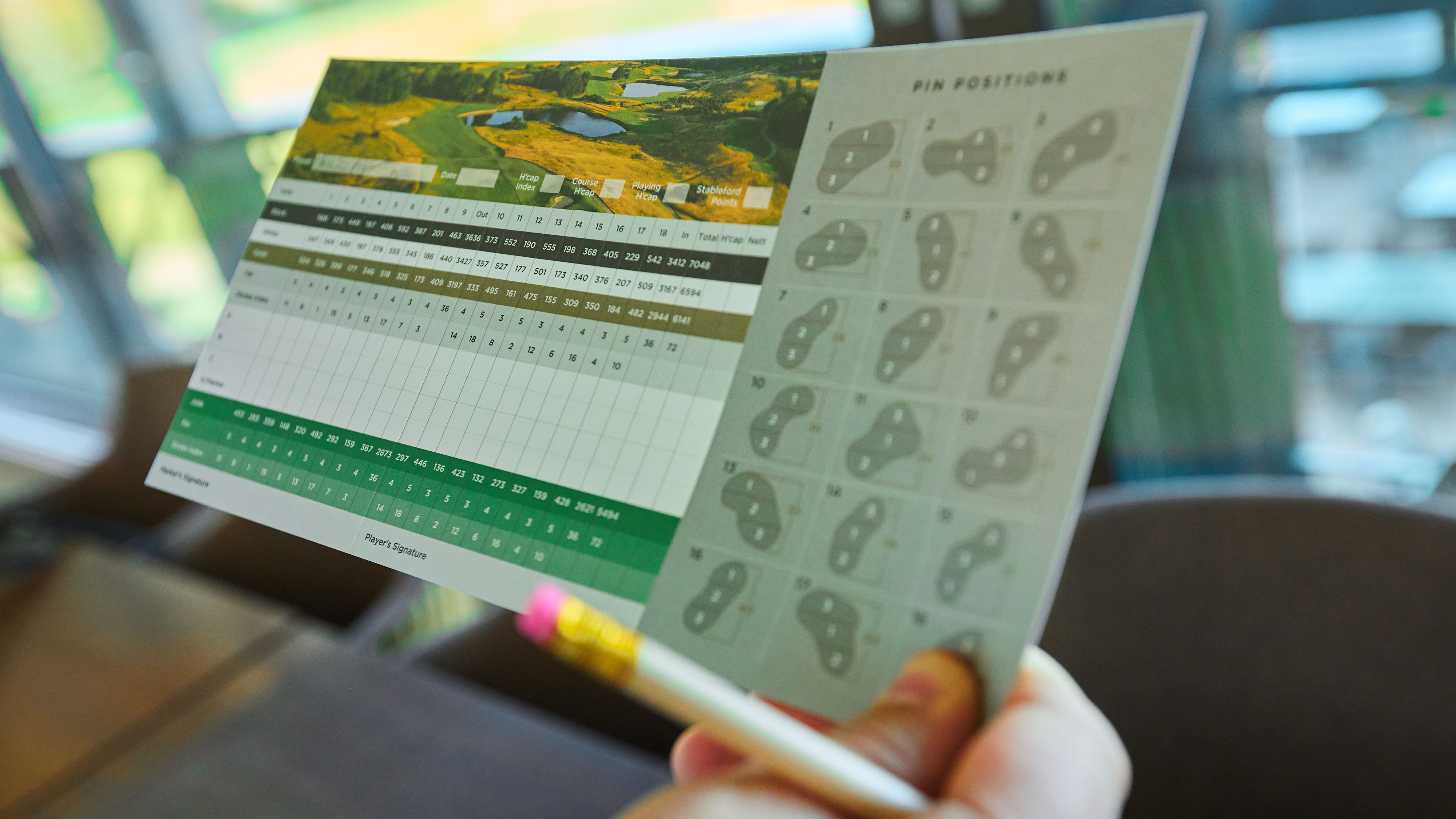 a close of up of a golfer holding a scorecard
