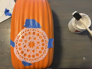stencil taped on pumpkin