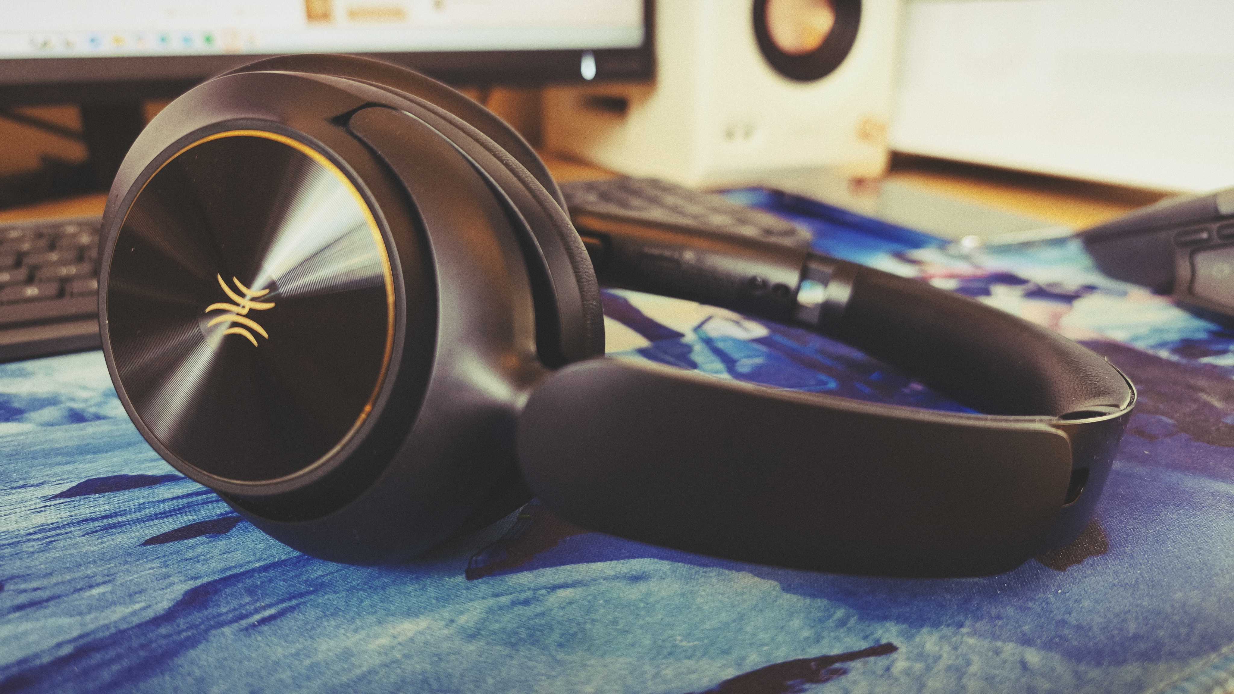 A pair of black OneOdio Focus A6 headphones on a gaming desk mat