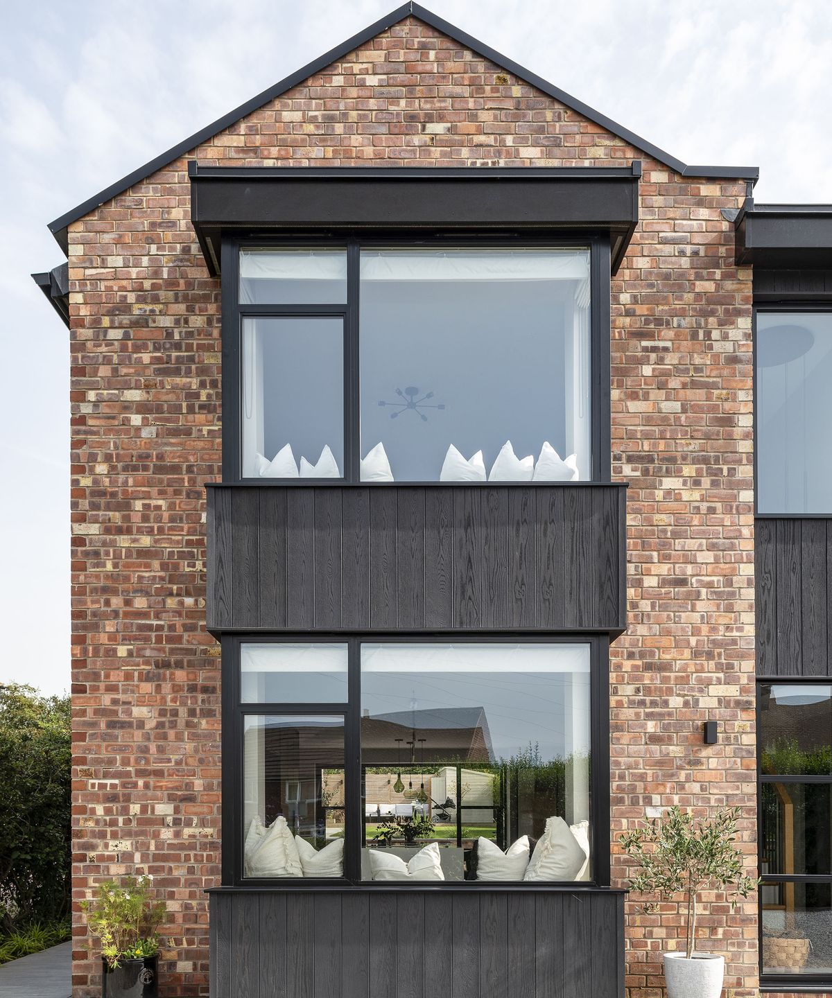 The pitched roof of a two-storey home which has been renovated and clad in timber and brick