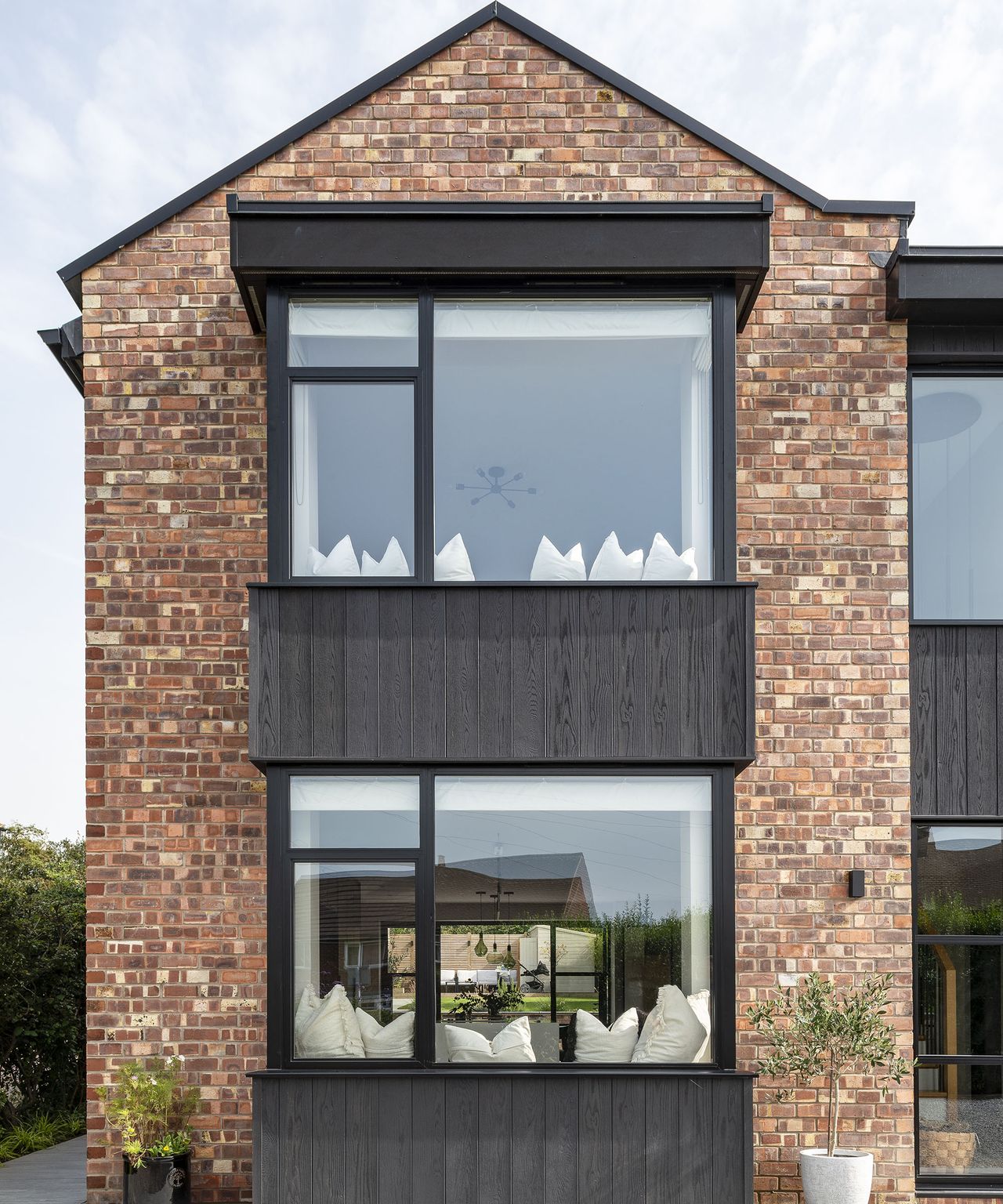 The pitched roof of a two-storey home which has been renovated and clad in timber and brick