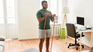 Man performs biceps curl with resistance band