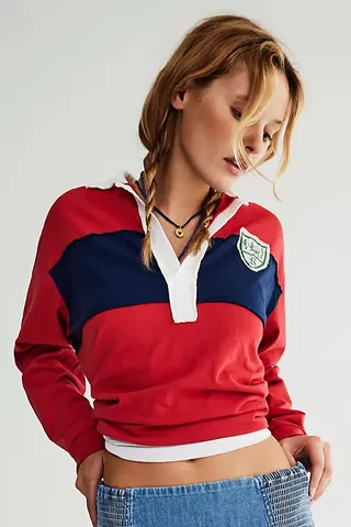 a model wears a rugby shirt in red with a navy stripe