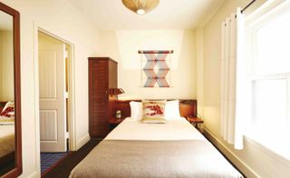 hotel bedroom with white wall and bed with white bedding