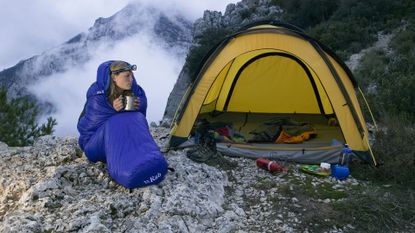 Woman in Sleeping Bag Next to Tent