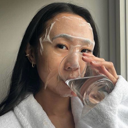Photo of creator @leatngu drinking water while wearing a sheet mask