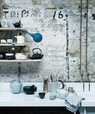 Pictures of kitchens showing a Japanese inspired scheme with distressed brick walls and open shelving.